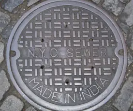 Una chica se cae por la boca de una alcantarilla