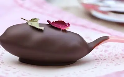 Cucharas de chocolate y pétalos de rosa.