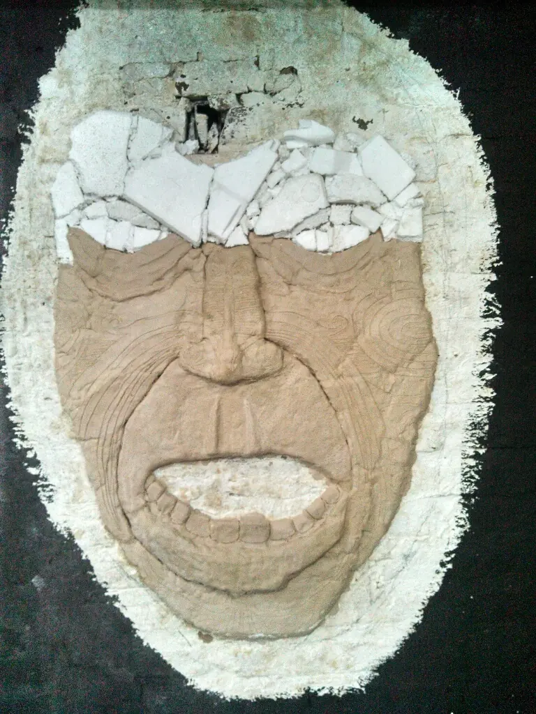 cara tatuada saliendo de la pared