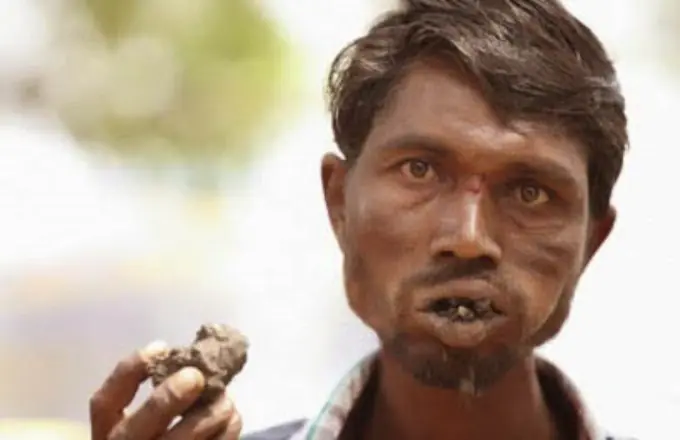 Un indio de la india se alimenta de barro
