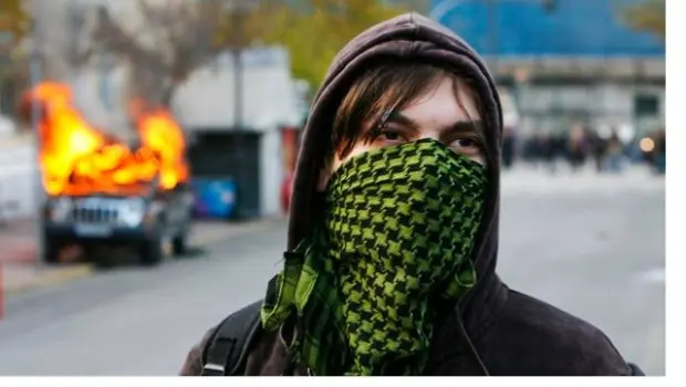 Anarquista empuja puerta que dice 'tire'