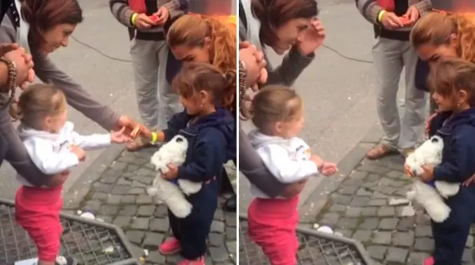 Una niña alemana recibe con dulces a una pequeña siria.