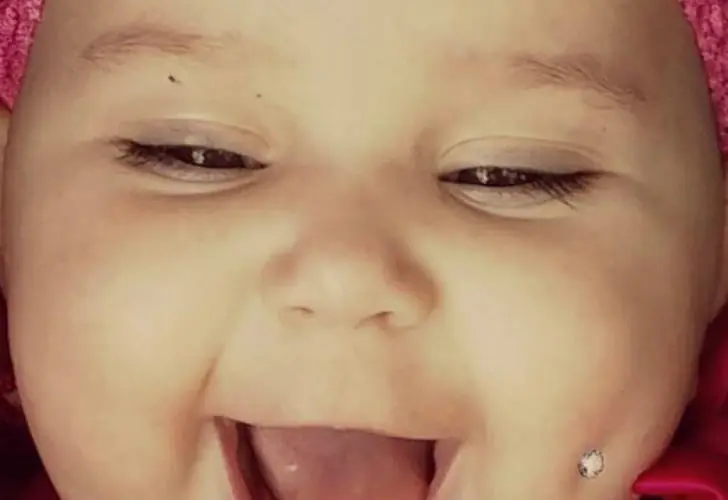 Conmoción bebe con un piercing en la mejilla